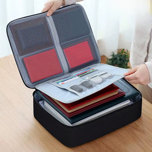 A black water-proof document storage bag with multiple compartments, some containing documents and personal items, displayed on a table.